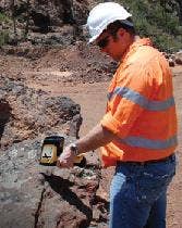 Delta Handheld XRF Analyzer testing a rock outside