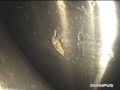 A defect in a wind turbine bearing capturing using a borescope.