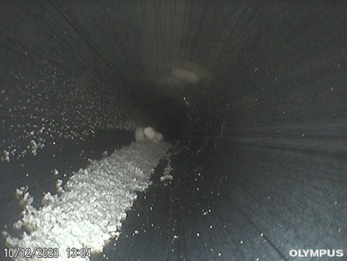 Videoscope or borescope inspection image of a stainless steel process pipe in a drug manufacturing plant of residue buildup leftover from a previous batch