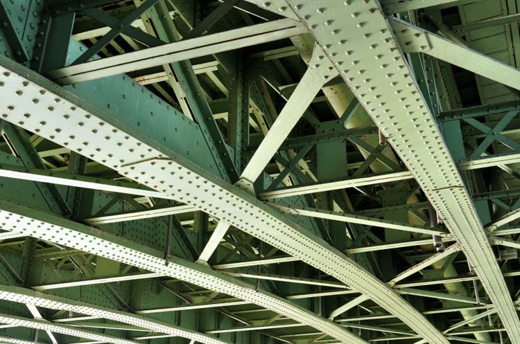 Close up of the girders of a steel bridge construction demonstrating the parts of the structure that are subjected to cyclical loading