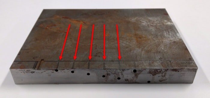 Custom-machined FBH test block showing the scan axes