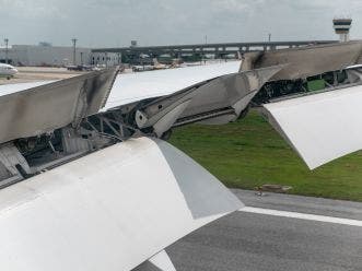 Foto desde la ventana de un avión que aterriza en el aeropuerto con los flaps del ala sujetos a carga cíclica al ser activados para frenar el descenso de la aeronave