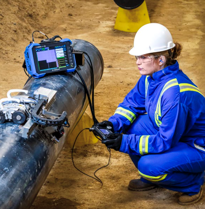 A person in a blue uniform and white hard hat Description automatically generated