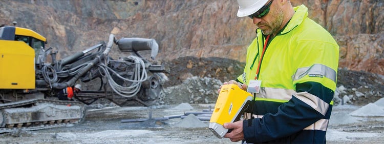 A person in a safety vest and hardhat looking at a device Description automatically generated, 画像